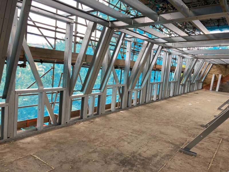 Interior of a rooftop extension at Seething Wells Campus, Kingston, showing braced light gauge steel framing and roof joists before boarding